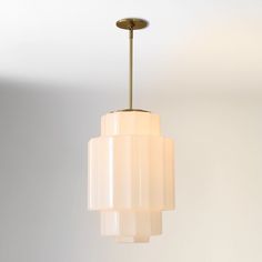 a light fixture hanging from the ceiling in a room with white walls and flooring