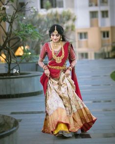 a woman in a red and yellow dress is walking down the street with her hands on her hips