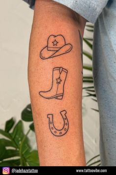 a man's arm with tattoos on it that include cowboy boots, a hat and a star