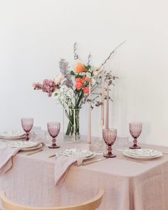 the table is set with plates and glasses