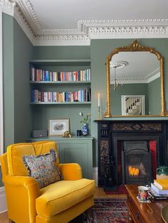 a living room filled with furniture and a fire place in front of a book shelf