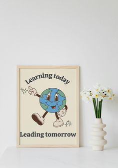 a white vase sitting on top of a table next to a framed poster with the words learning today leading tomorrow