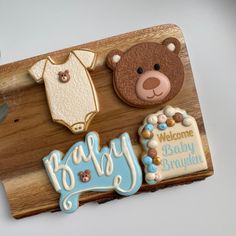 a baby shower cake with teddy bear, welcome baby sign and cookies in the shape of bears