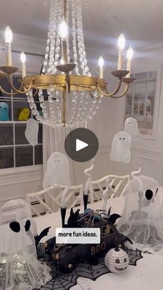 a chandelier hanging from the ceiling in a room with ghost decorations on it