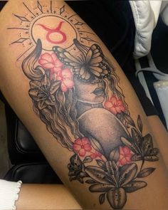 a woman's thigh with flowers and an astro sign on the side, in black and grey