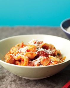 a bowl of pasta with sauce and parmesan cheese