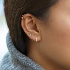 a woman wearing ear cuffs with two small diamonds on them