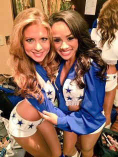 two cheerleaders are posing for the camera