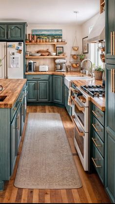 a kitchen with wooden floors and green cabinets, an area rug on the floor in front of the stove