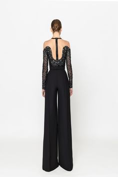 Elevate your style with the Naja Saade RTW23-09 black crepe jumpsuit. Featuring an intricately embroidered top and a removable belt, this jumpsuit exudes sophistication and elegance. Make a statement at any event with this timeless piece. Elegant Embellished Jumpsuits And Rompers For Cocktail, Elegant Embellished Cocktail Jumpsuits And Rompers, Chic Embellished Jumpsuit For Gala, Chic Embellished Jumpsuits And Rompers For Formal Occasions, Chic Embellished Formal Jumpsuits And Rompers, Formal Chic Embellished Jumpsuits And Rompers, Elegant Black Jumpsuits And Rompers For Gala, Elegant Embellished Formal Pantsuit, Elegant Floor-length Jumpsuits And Rompers For Evening