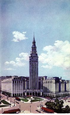 an old photo of a very tall building with a clock tower in the middle of it