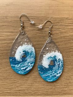 the earrings are decorated with blue and white waves