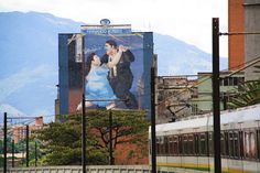 a billboard on the side of a building with a man and woman kissing each other