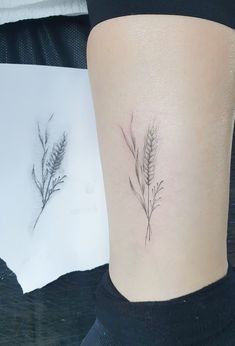 a small tattoo on the ankle of a woman's lower leg with two plants