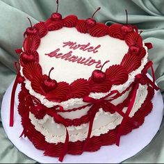 a heart - shaped cake with the words model revolution written on it and red ribbons