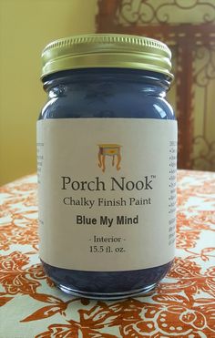 a jar of blue paint sitting on top of a table