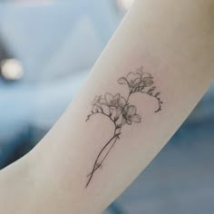 a small flower tattoo on the arm