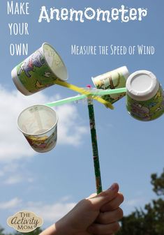 a person holding up two cups with toothbrushes attached to them in the air