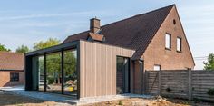 the house is made out of wood and has glass doors that open to let in light