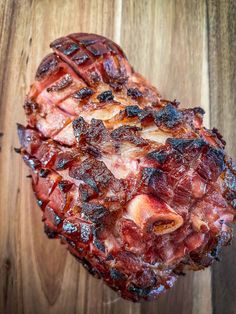 a heart shaped piece of meat sitting on top of a wooden table