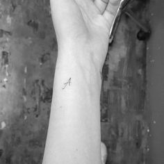 a woman's arm with a small tattoo on the left side of her wrist