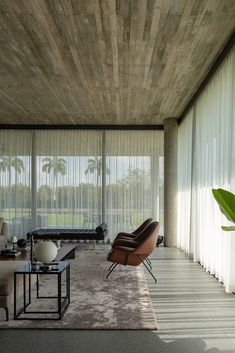 a living room filled with lots of furniture and large glass doors leading to the outside