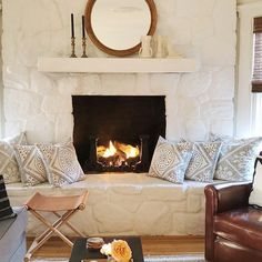 a living room filled with furniture and a fire place next to a couch in front of a fireplace