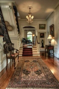 an ornate entry way with stairs and rugs