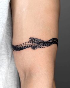 a woman's arm with a snake tattoo on the left side of her body