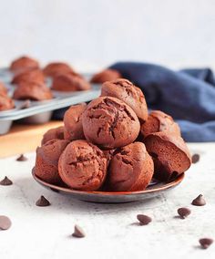 a plate full of chocolate muffins sitting on a table next to a baking pan