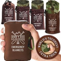 a person is holding an emergency blanket in front of four different pouches with the words don't die at the woods and emergency blankets printed on them