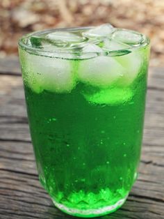 a green drink with ice on a wooden table