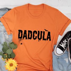 Funny Halloween T Shirt, Family Halloween Tee, Halloween Costume, Mens Halloween T-Shirt, Funny Dad Shirts, Halloween Dadcula Shirt, Trick or Treat Shirt, Halloween Party Are you looking for the perfect men's Halloween costume? Our Halloween Dadcula T-Shirt is a must-have for any funny dad out there! Let the whole family join in on the fun with our family Halloween shirts. This Halloween costume is both comfortable and stylish, making it ideal for any Halloween event. Stand out from the crowd wi Orange Halloween T-shirt With Letter Print, Orange Letter Print Shirt For Halloween, Halloween Orange T-shirt With Letter Print, Halloween Costume Mens, Family Halloween Shirts, Mens Halloween Shirts, Boutique Tees, Mens Halloween, Dad Shirts