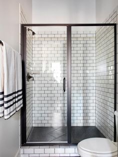 a white toilet sitting next to a walk in shower