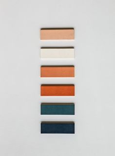 five different shades of paint on a white surface with one color swatch in the middle