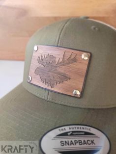 If you've been looking for that patch hat thats unlike all the rest, look no further. These patches are made up of hand dyed genuine leather with a laser engraved walnut overlay, all bonded and riveted to the hat producing a look that will be scoring compliments everywhere you go.  it should go without question that a special patch like this made from wood should be hand cleaned only. The wood has been treated with beeswax and mineral oil to give it a beautiful sheen and also help repel moisture Brown 5-panel Snapback Hat With Leather Patch, Custom Brown Snapback Baseball Cap, Custom Outdoor Trucker Hat With Leather Patch, Custom Trucker Hat With Leather Patch For Outdoor, Custom Trucker Hat With Leather Patch Snapback, Custom Snapback Trucker Hat With Leather Patch, Leather Patch Hat Ideas, Hat Patch Ideas, Personalized Hats