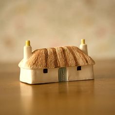 a small house made out of clay sitting on top of a wooden table