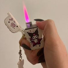 a person holding a lighter shaped like a cat with a key chain attached to it