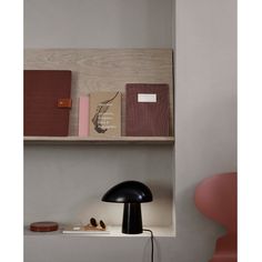 a shelf with books and a lamp on it