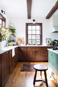 a kitchen filled with lots of wooden cabinets and counter top space next to a window