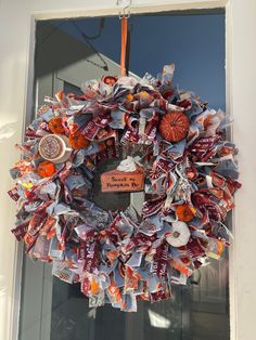 a wreath with candy and candies hanging on the front door to someone's house