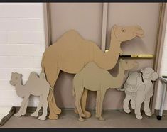 a group of wooden cut out animals standing next to each other in front of a wall