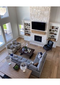 an aerial view of a living room with couches, chairs and a fireplace in the center