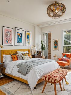 a bed sitting in a bedroom next to two orange chairs