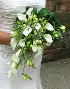 a bride holding a bouquet of white flowers