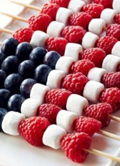 an american flag made out of marshmallows and raspberries on a stick