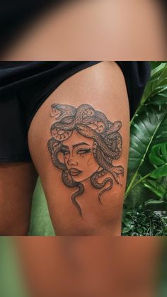 a woman with a snake tattoo on her thigh