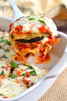 a spoon full of lasagna casserole being lifted from a dish