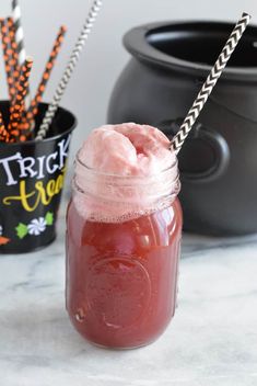 a mason jar filled with ice cream next to halloween decorations and black caulder