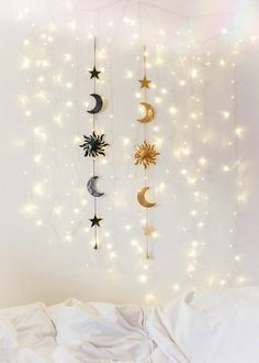 a white bed topped with lots of lights and stars hanging from the side of it